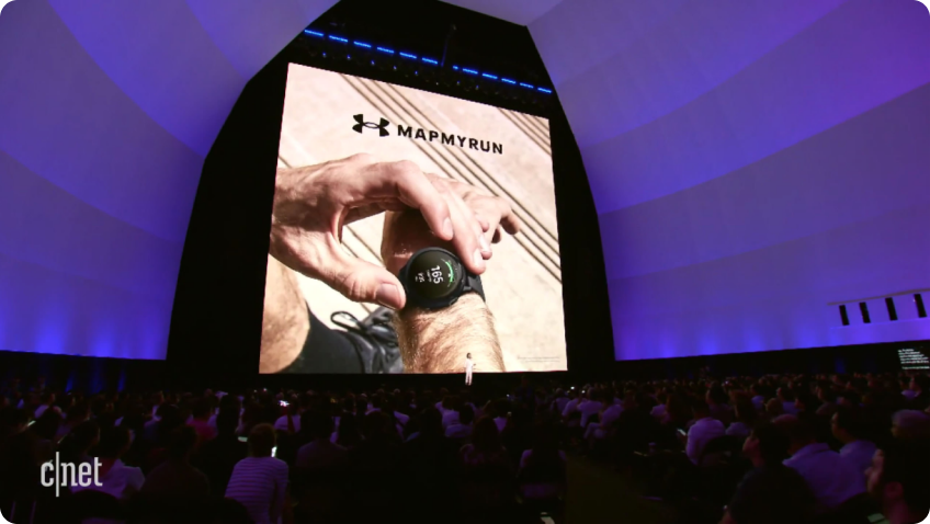 Samsung Unpacked conference stage showing UA MapMyRun form coaching